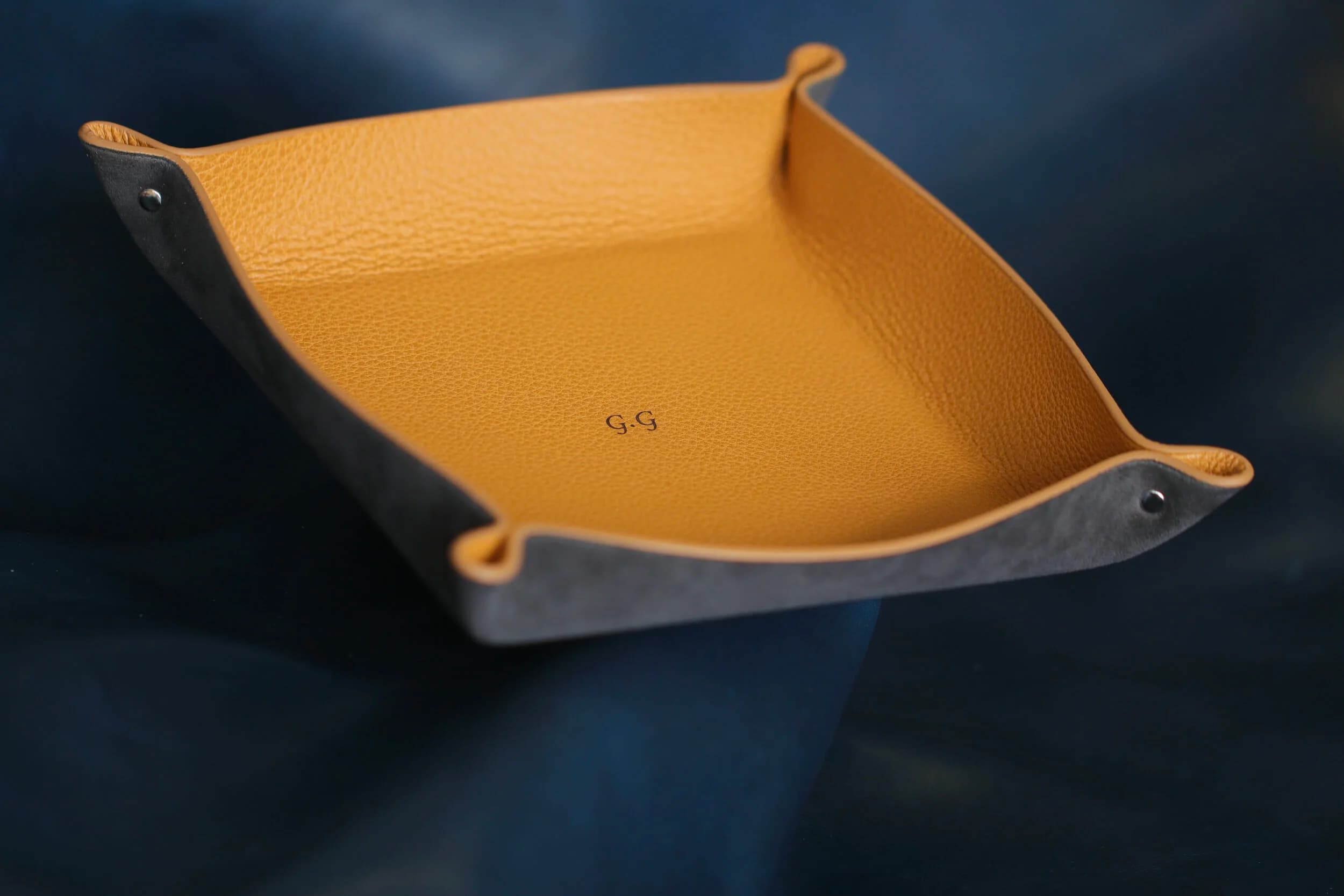 A two-tone orange and blue leather valet tray.