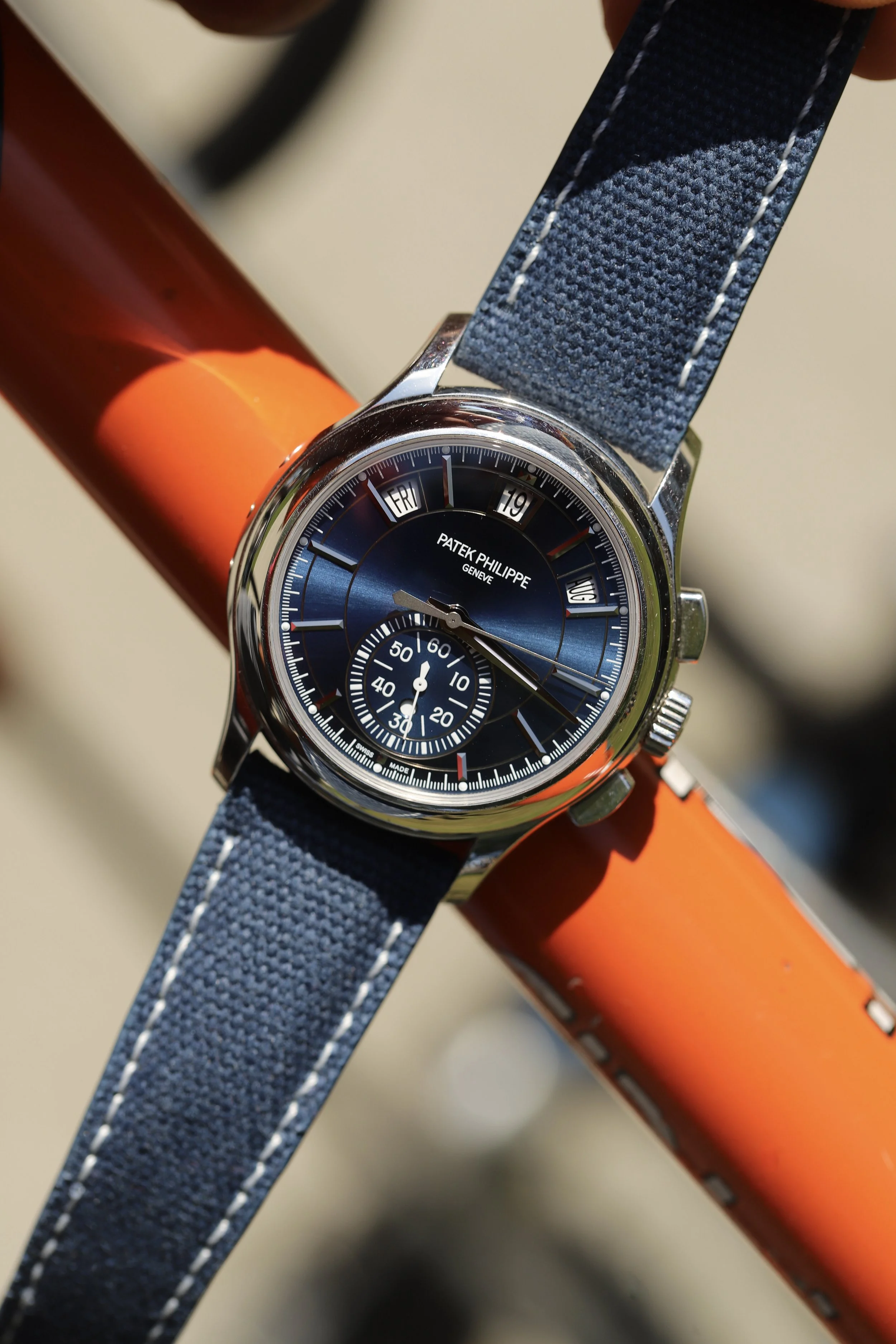 A watch with a deep-blue Aaron Bespoke leather strap on a denim background.
