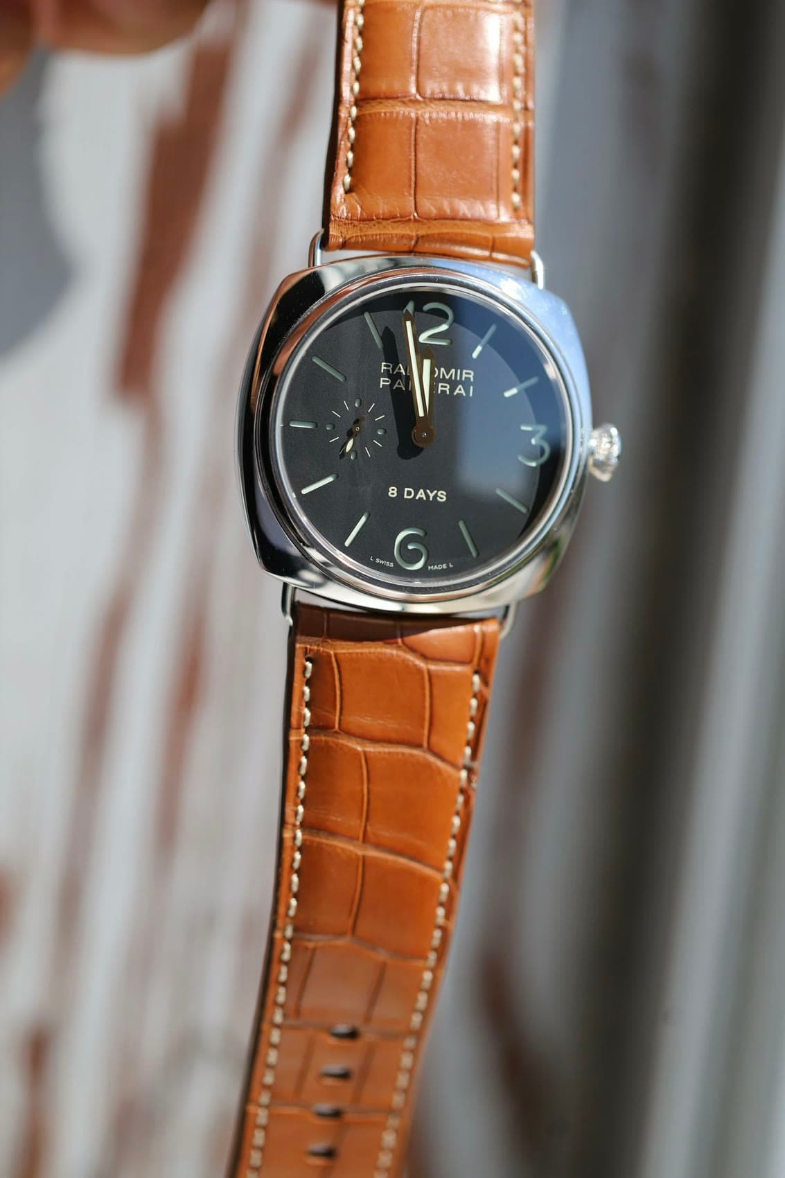 A Panerai Radiomir 8 Days on honey alligator, held up to the light.