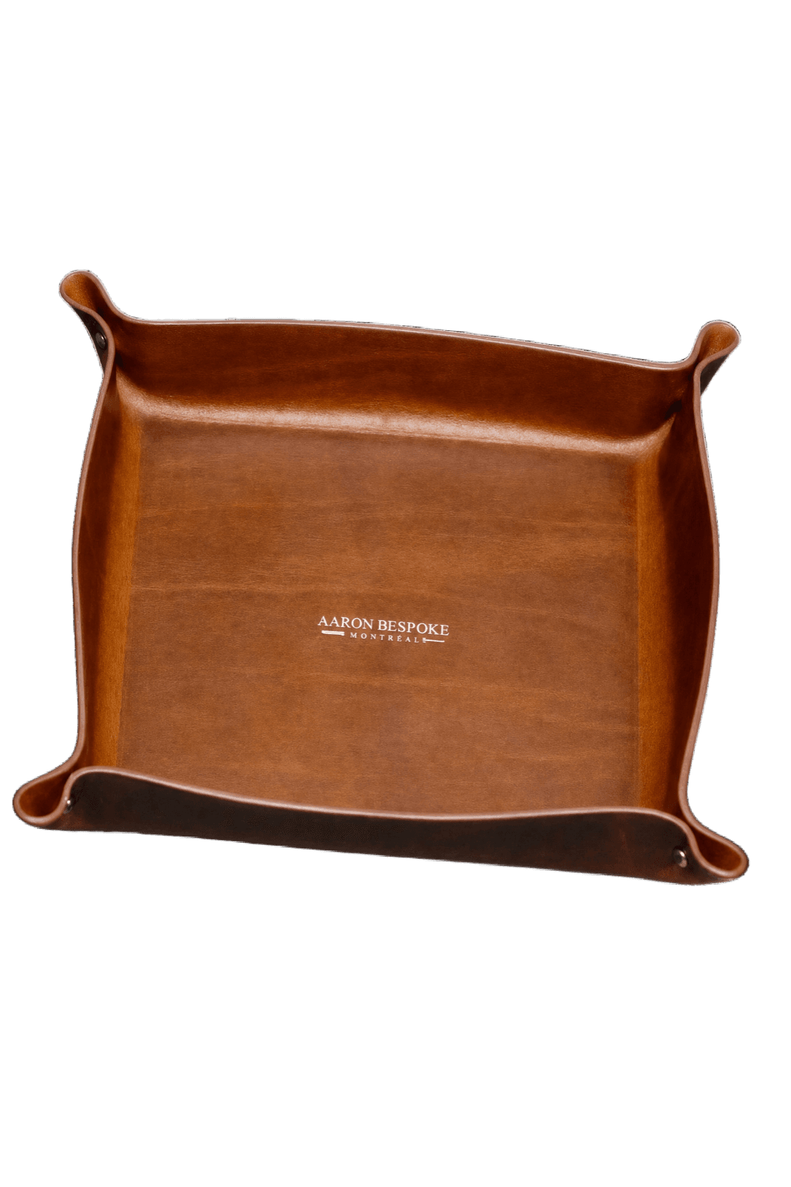 A cognac leather valet tray embossed with the Aaron Bespoke, Montréal mark.